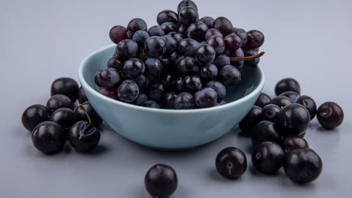 Fresh black grapes in blue ceramic bowl