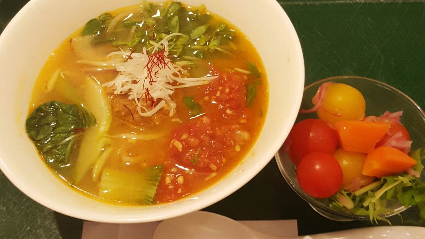 Colorful vegetable noodle soup with salad