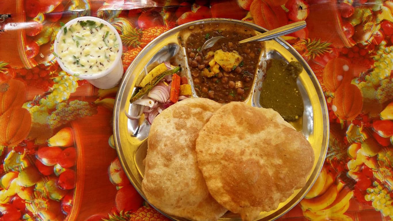 Indian chole bhature thali with condiments