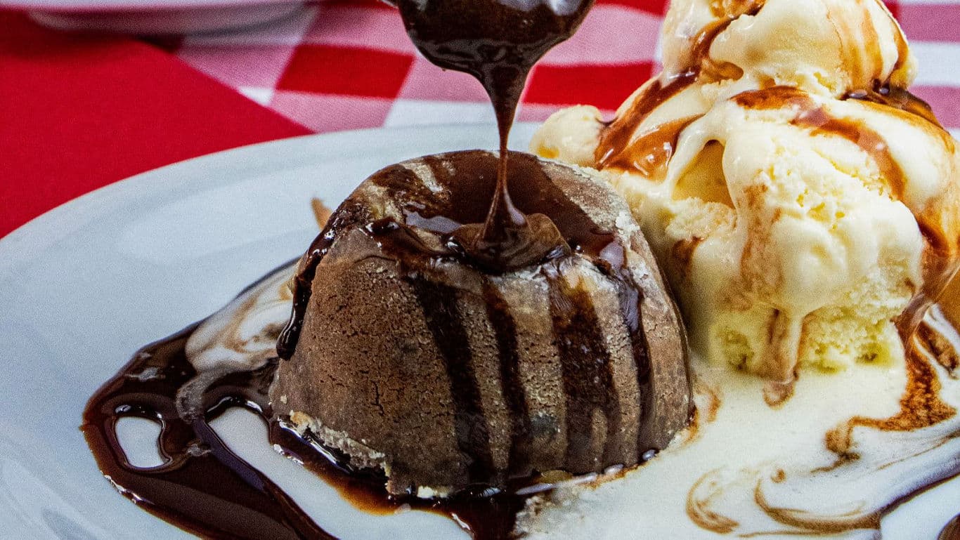 Chocolate Cake Slice Getting Lifted In A Spatula From The Whole Cake