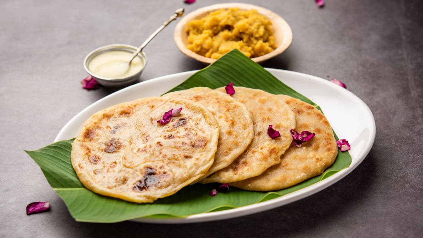 Traditional Indian sweet paratha with garnish on plate