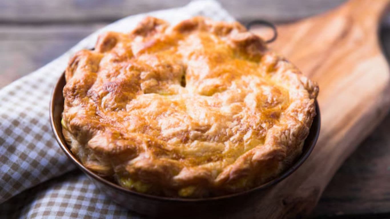 Golden baked pie on rustic wooden board
