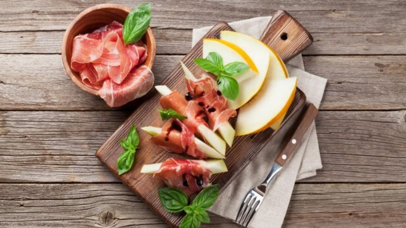 Prosciutto and melon appetizer on rustic board