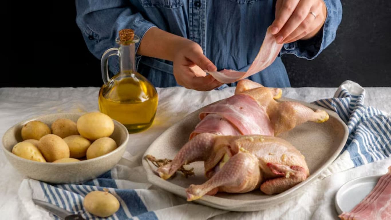 Preparing poultry with bacon and potatoes for roasting