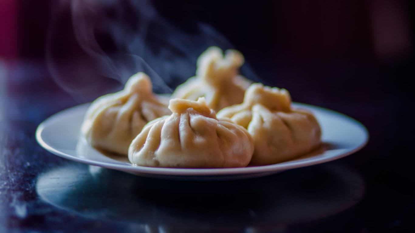 A plate of steaming momos on a plate