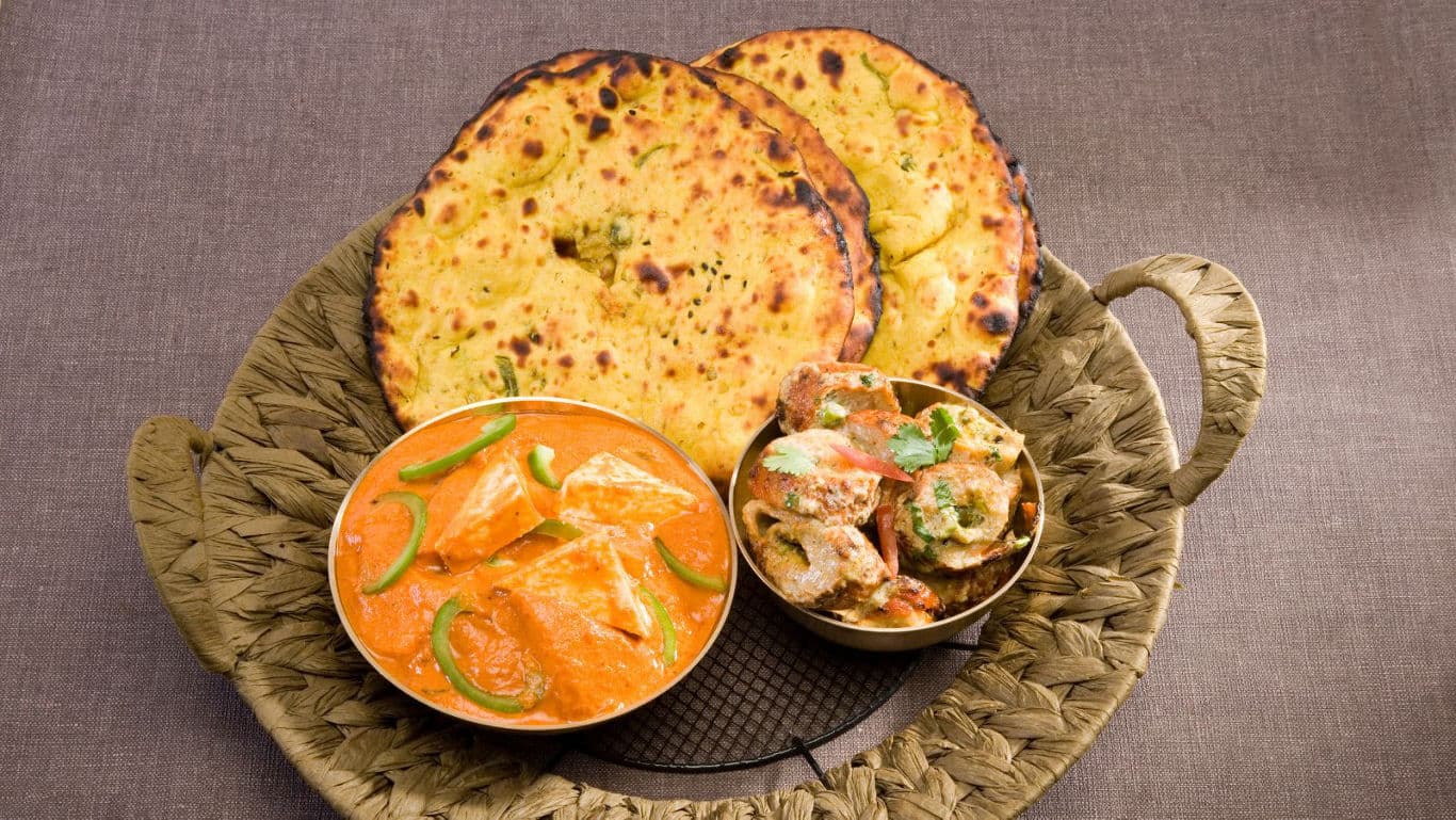Indian curry with naan bread on platter