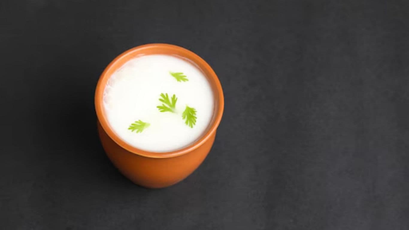 Clay cup of yogurt garnished with herbs