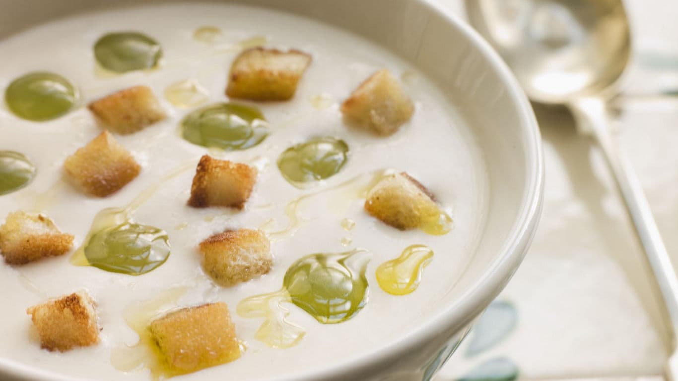 Creamy soup with croutons and green garnish