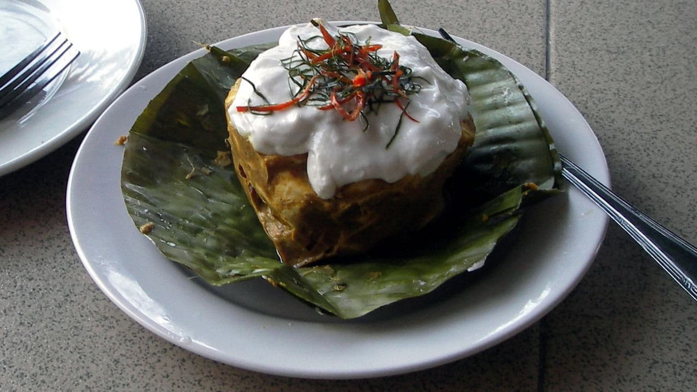 Traditional steamed fish curry served on banana leaf