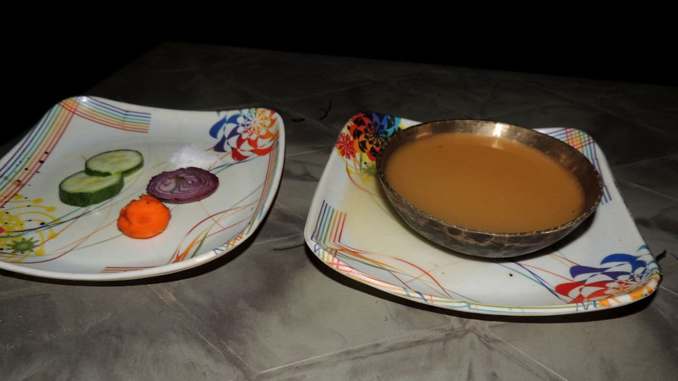 Traditional tea in metal bowl with vegetable sides