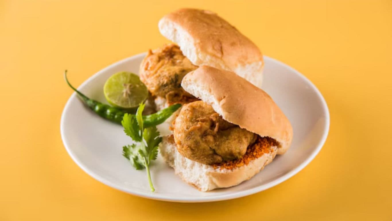 Indian vada pav served on white plate with garnish