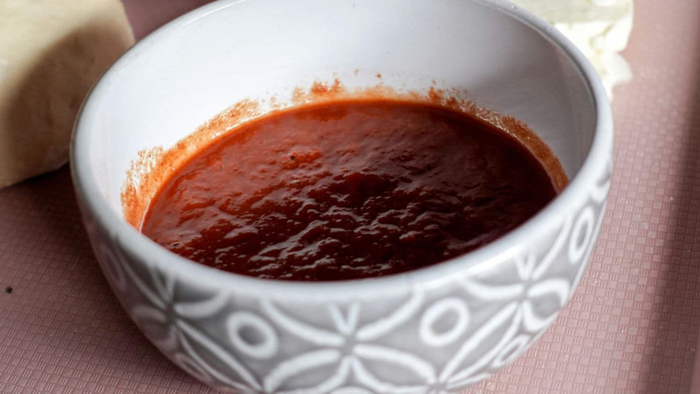 White patterned bowl filled with tomato sauce