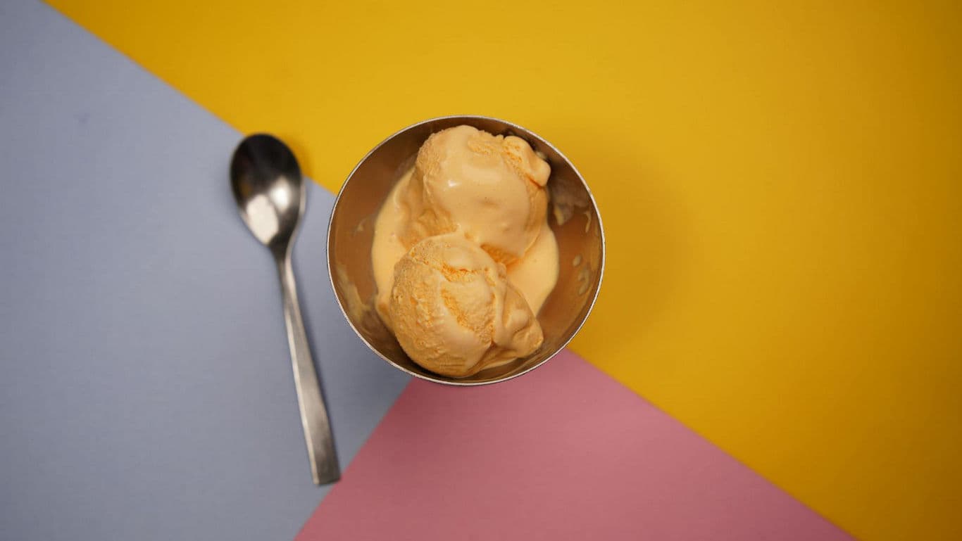 Vanilla ice cream scoops on colorful background