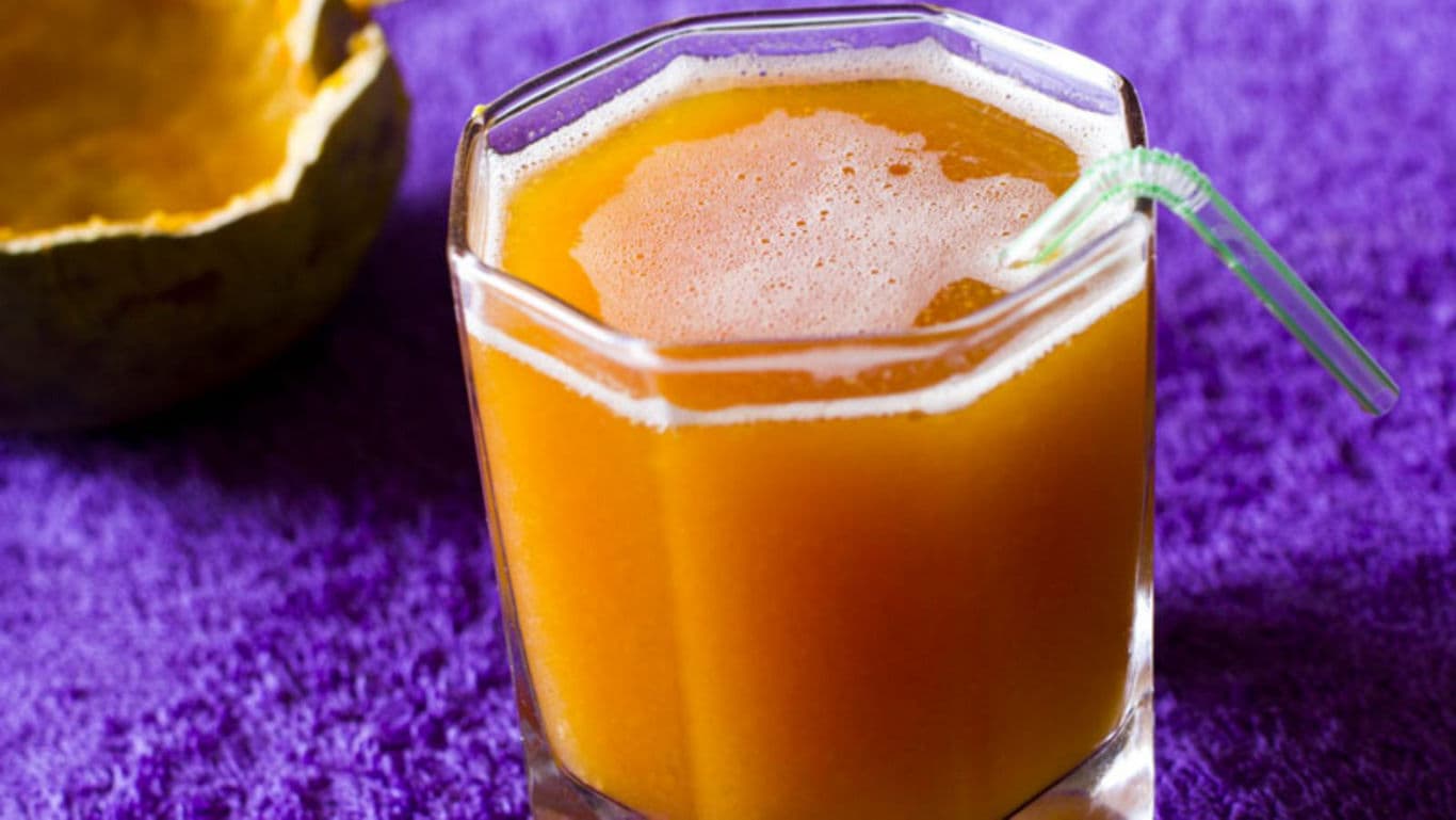 Fresh orange juice in faceted glass with straw