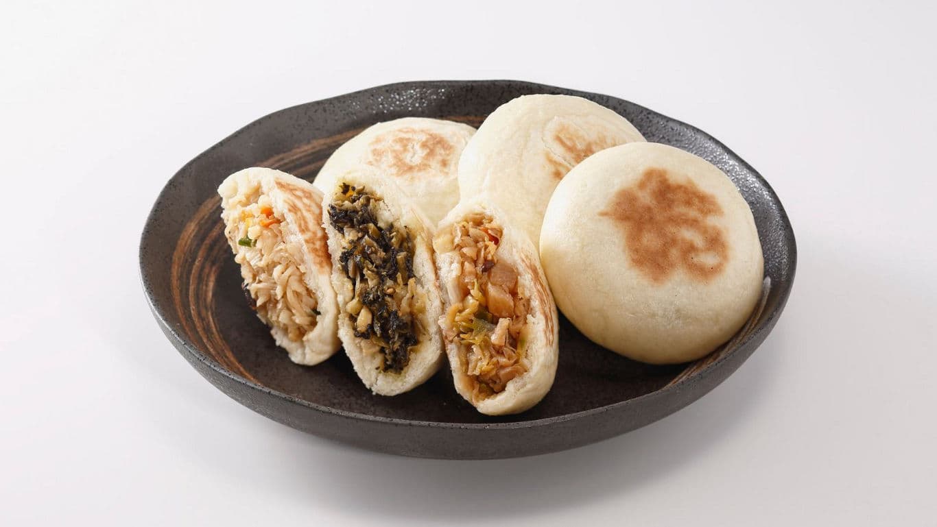 Assorted steamed buns with savory fillings on plate