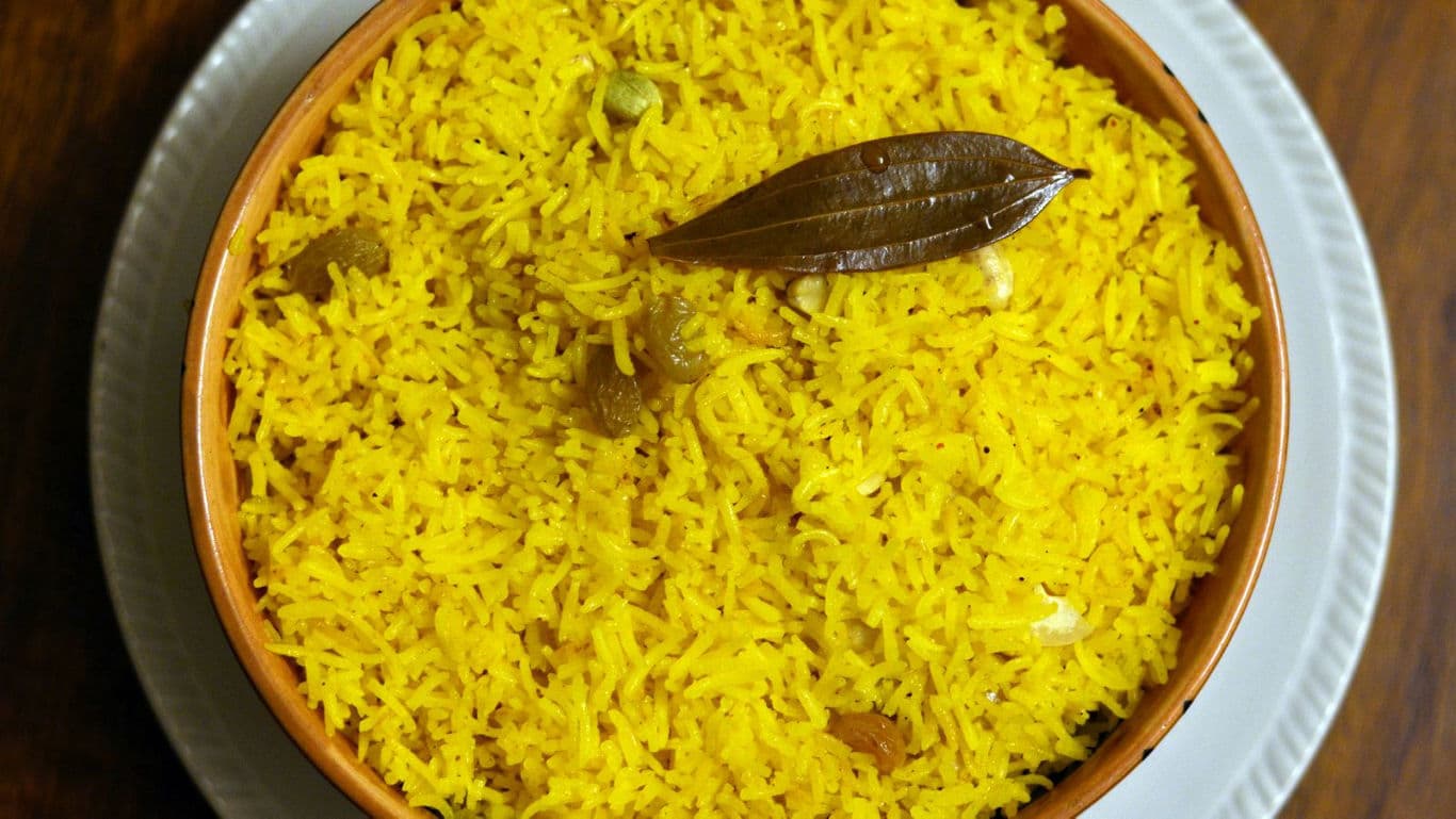 Bowl of Yellow Spiced Rice with Bay Leaf Garnish