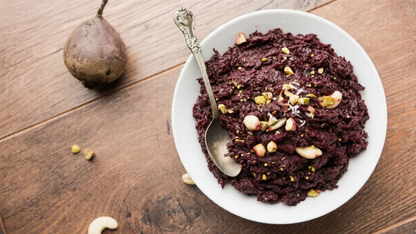 Beetroot porridge with nuts on wooden table