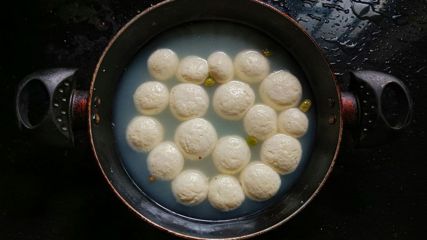 Rasgulla sweets simmering in sugar syrup