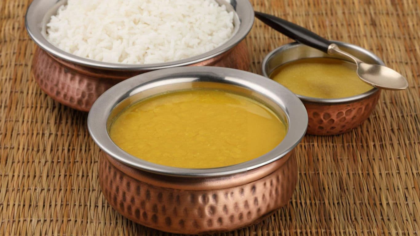 Traditional Indian dal and rice served in copper bowls