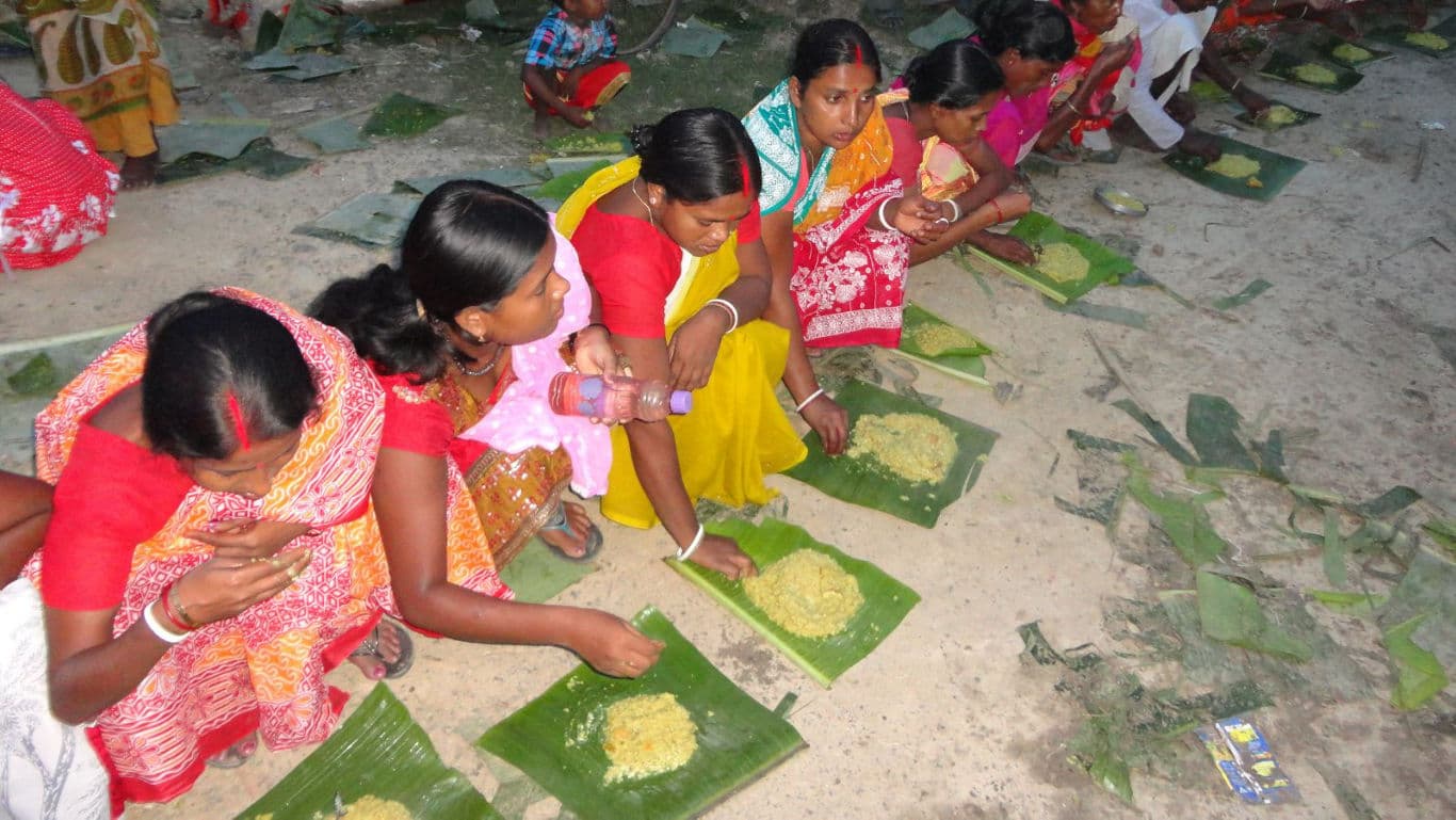 Women eating traditional meal on banana leaves