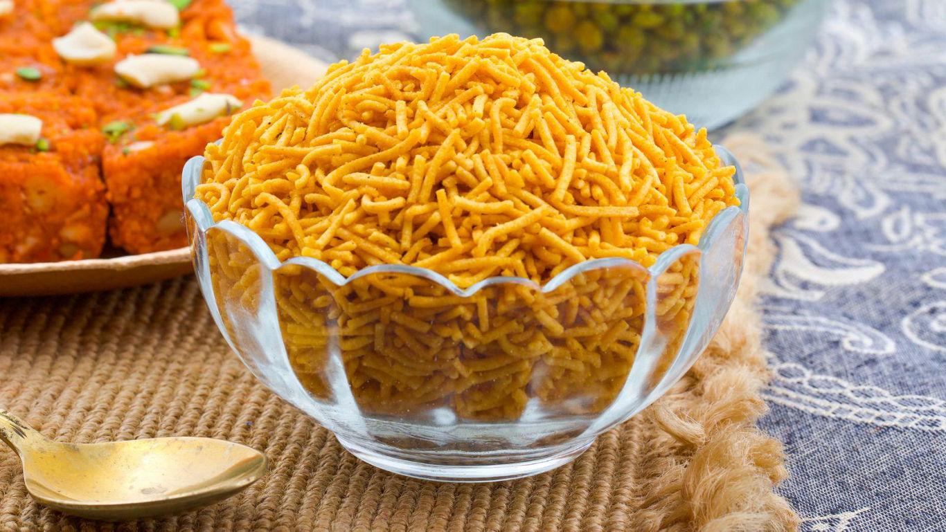 Glass bowl of crispy Indian snacks