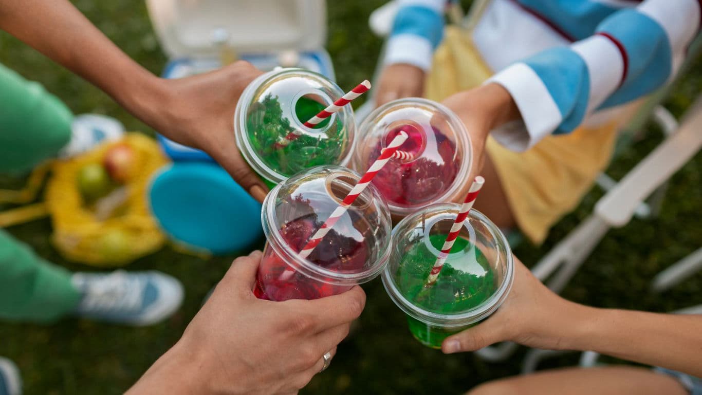 Friends Toasting with Colorful Summer Drinks Outdoors