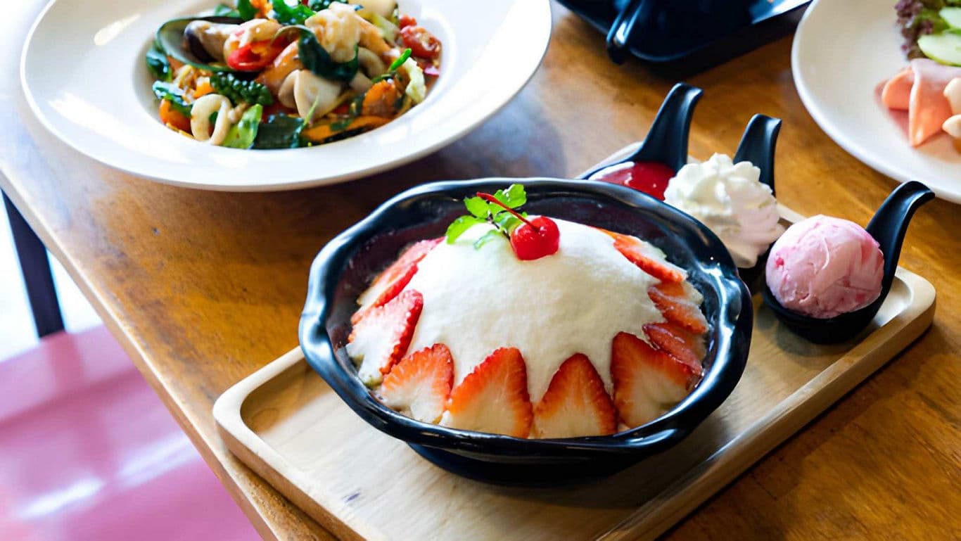 Strawberry shaved ice dessert with ice cream scoops