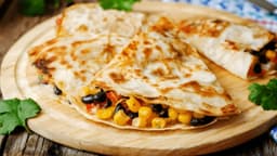 Black bean quesadillas on a wooden round board