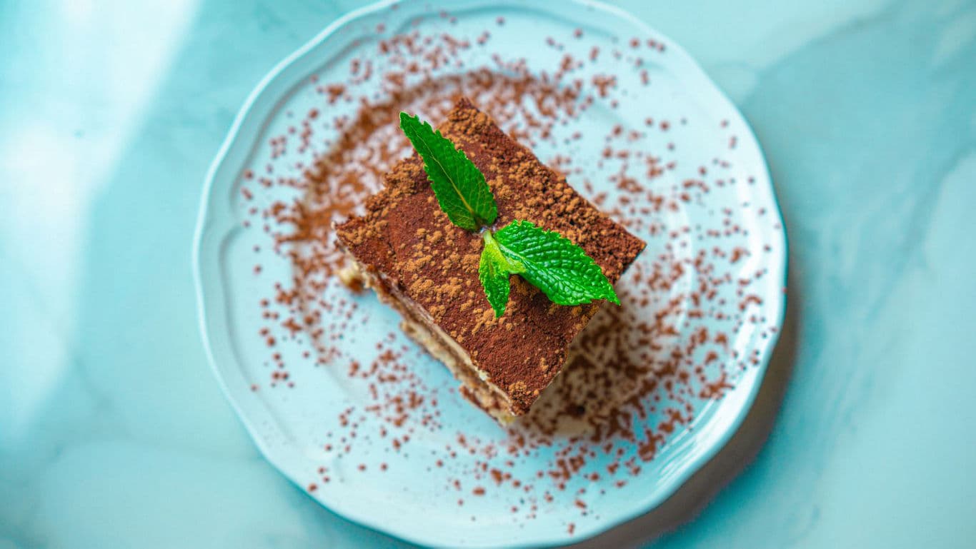 Tiramisu dessert slice with cocoa and mint