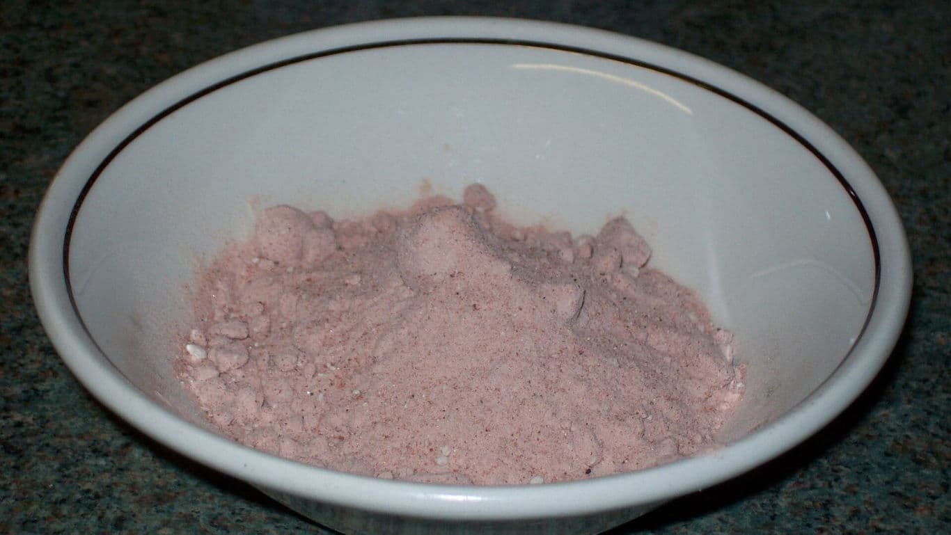 Pink powder in white ceramic bowl on countertop
