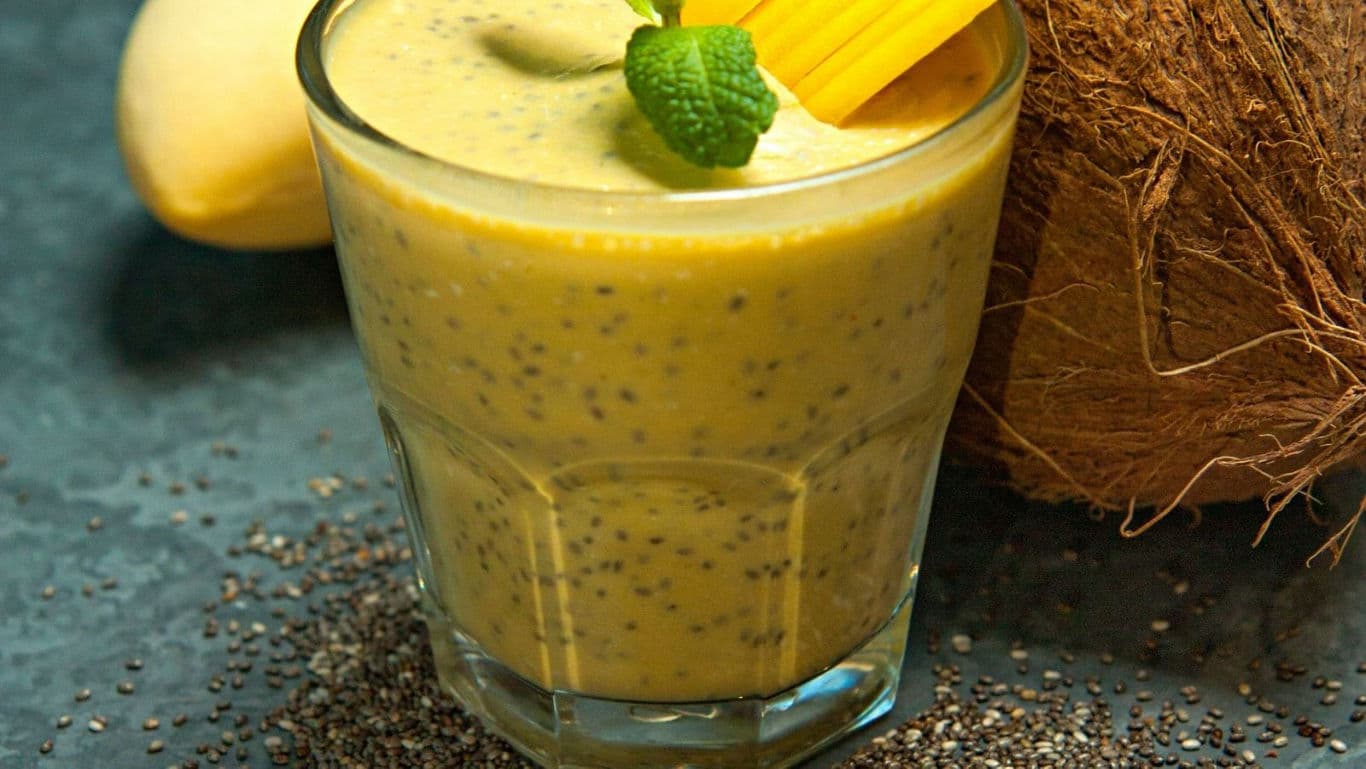 Mango chia smoothie in glass with coconut