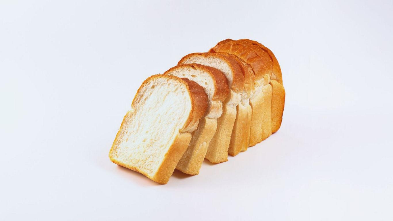 Sliced white bread loaf on white background