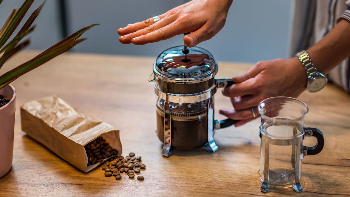 a French press with coffee beans