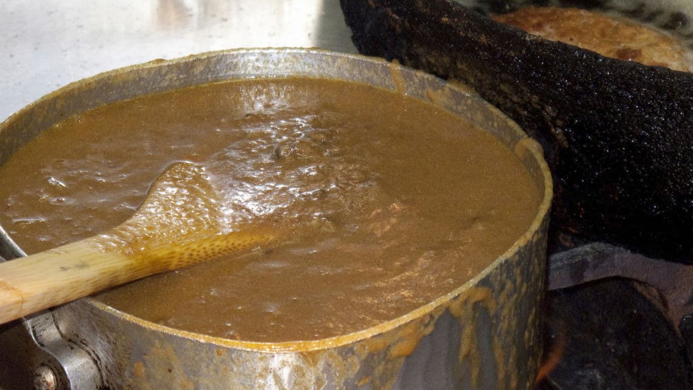 Thick brown sauce simmering in saucepan