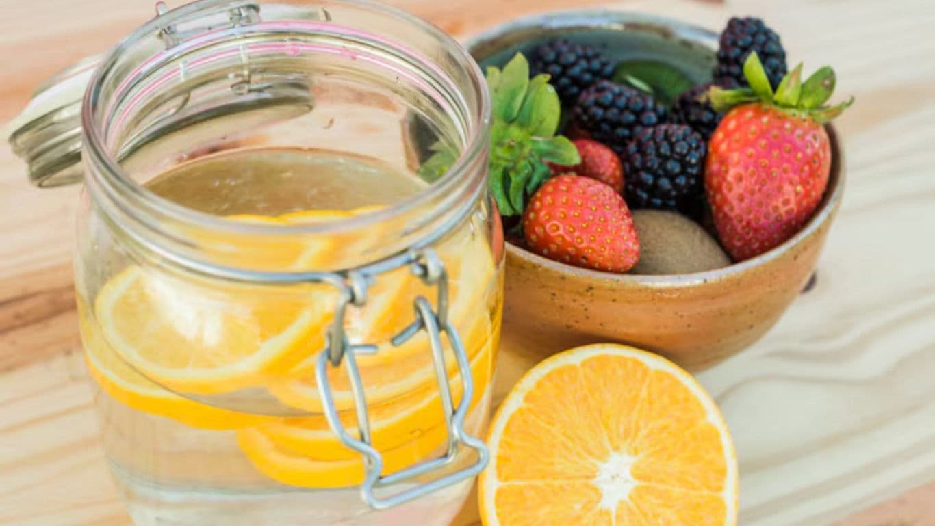 Fresh fruit bowl and citrus water on wood table