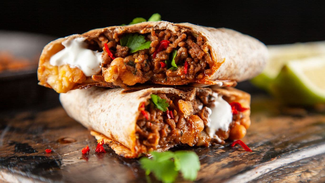 Close-up of beef burrito halves with fresh garnish