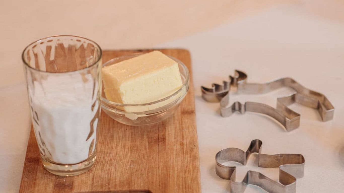 Butter and milk on wooden board with cookie cutters