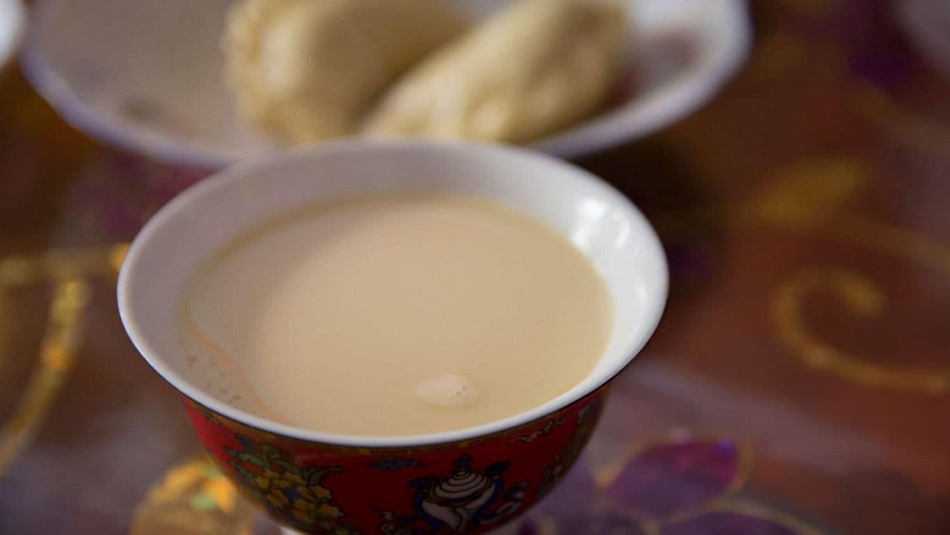 Traditional Milk Tea in Ornate Red Bowl on Table