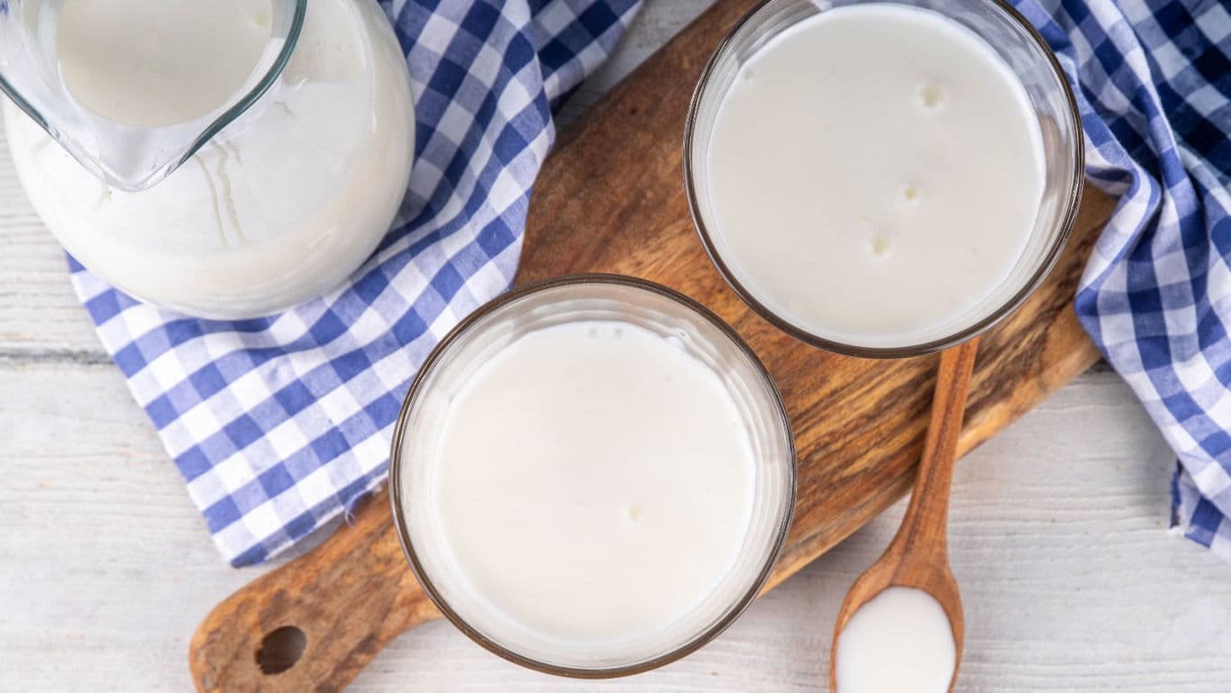 Fresh milk in glasses with wooden serving board