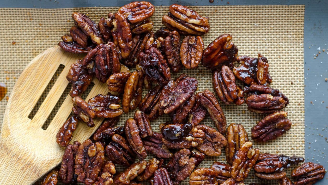 Glazed Roasted Pecans on Baking Sheet with Spoon