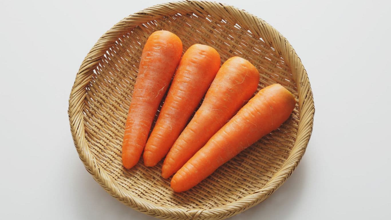 Fresh carrots in woven basket
