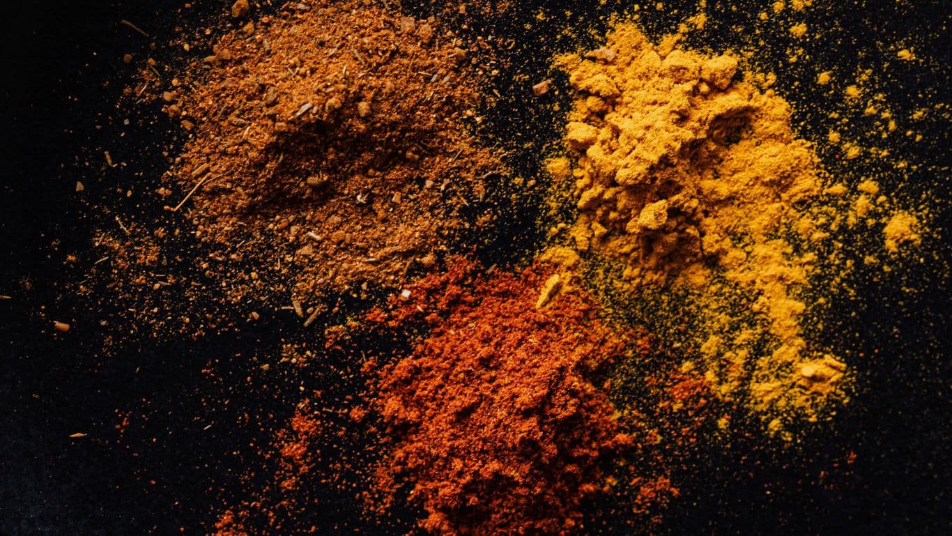Colorful Assorted Ground Spices on Dark Surface