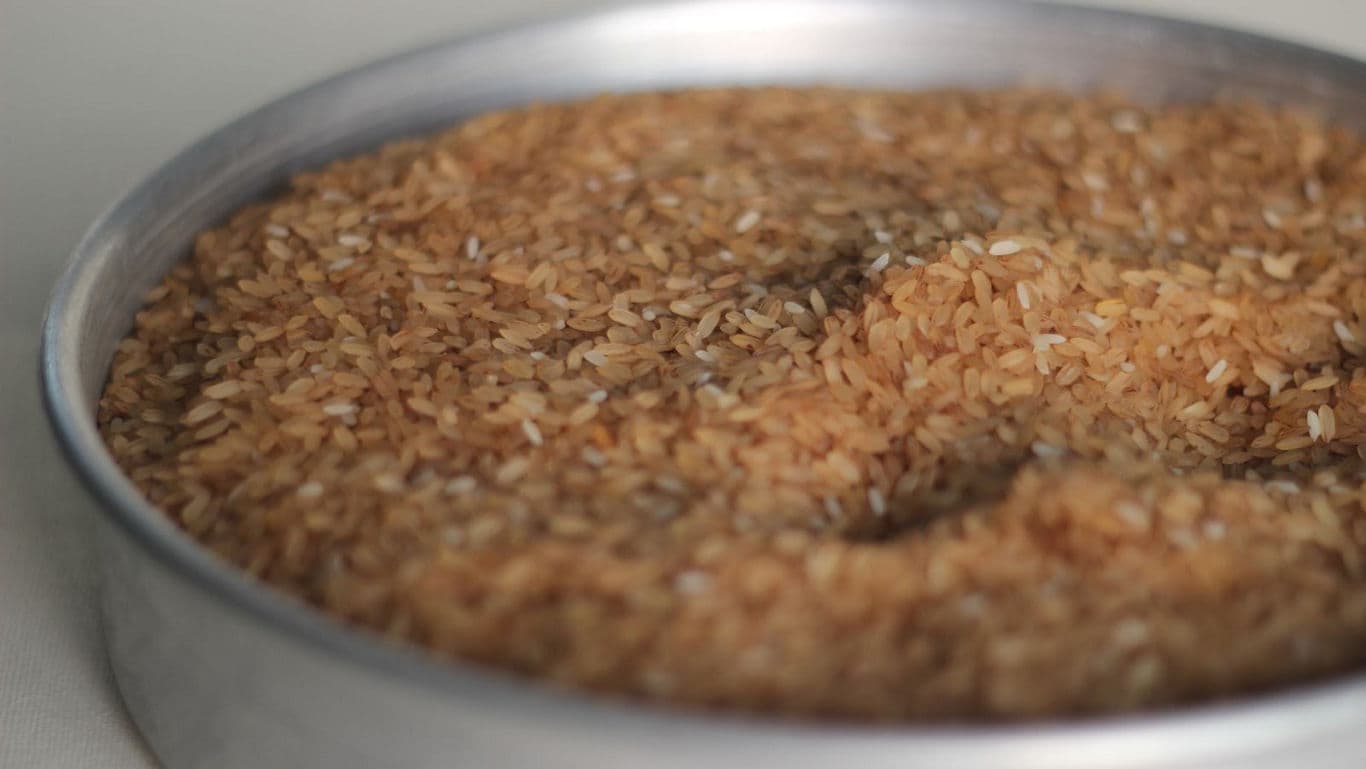Close-up of brown rice in metal pan