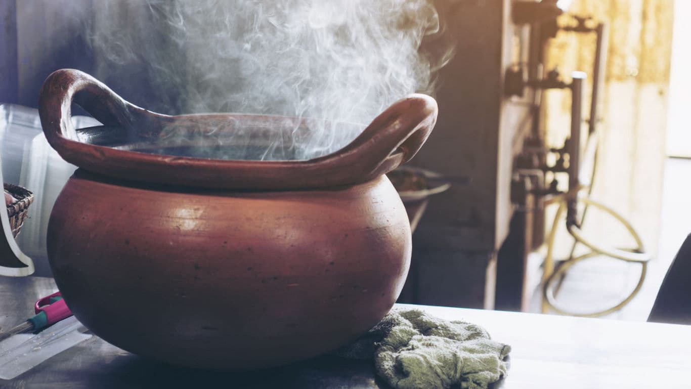 Steaming clay pot on kitchen counter with sunlight