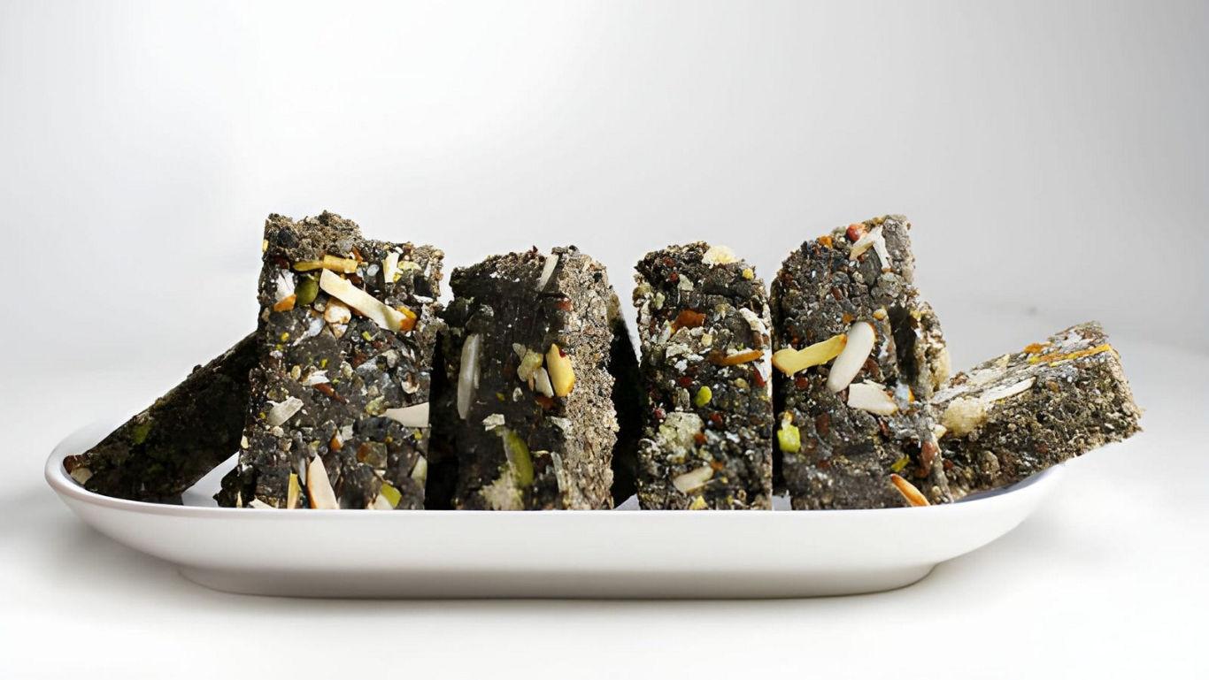 Black sesame bars with nuts on plate