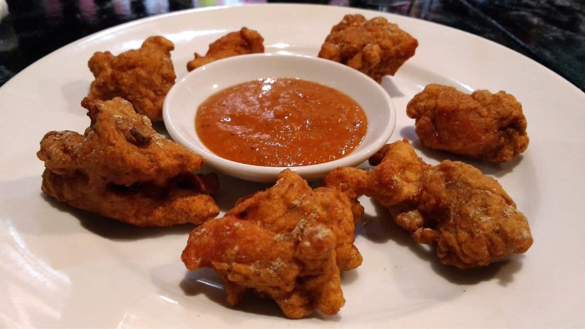 Chicken pakora surrounding a bowl of sauce