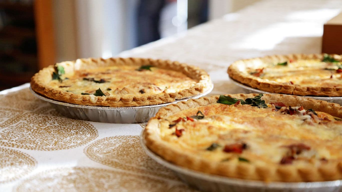 Freshly baked quiches on patterned table
