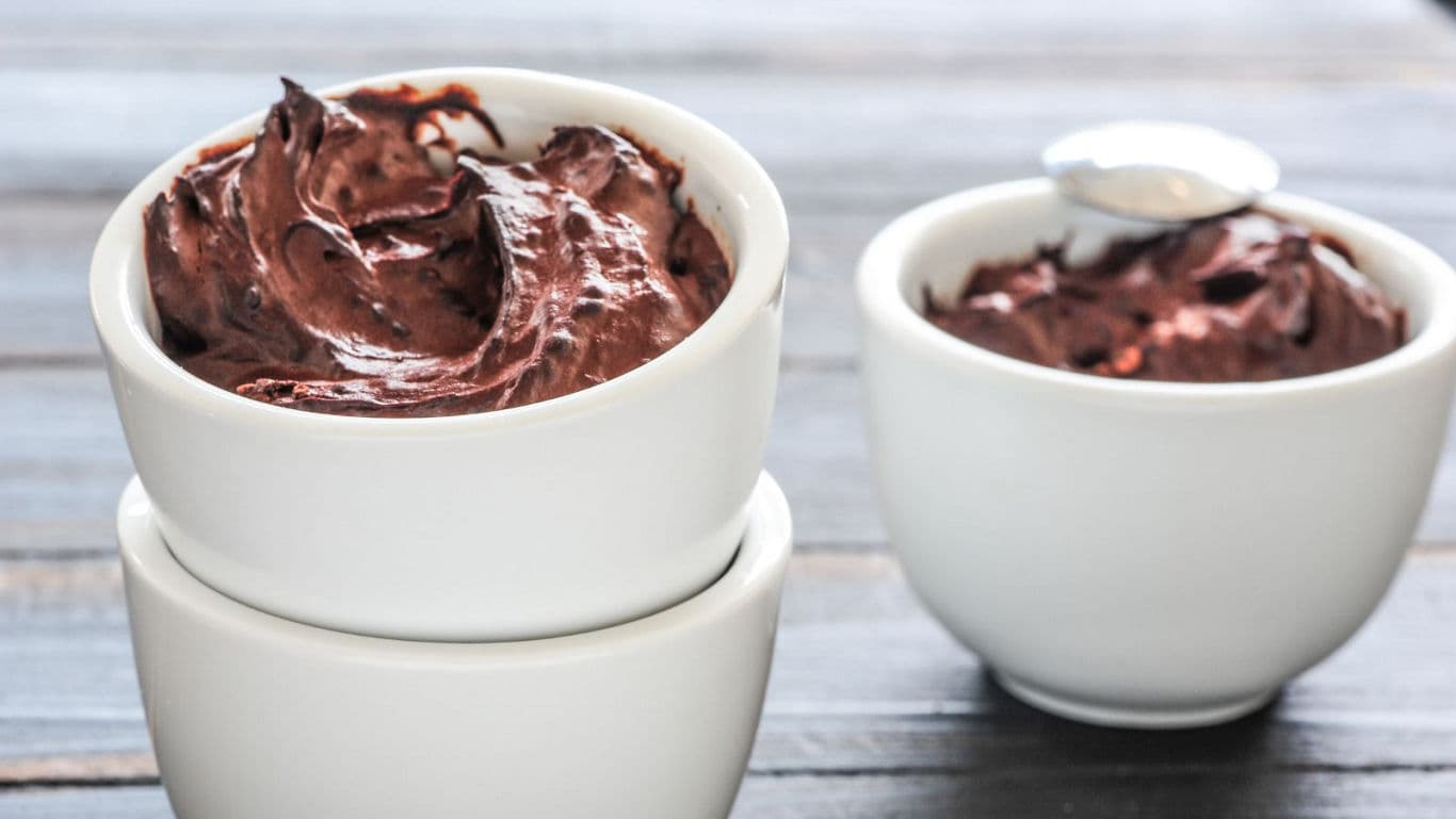 Chocolate mousse in white ceramic bowls on table