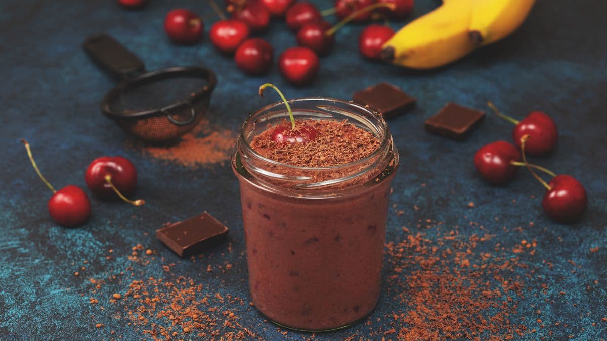 Smoothie surrounded by cherries and bananas