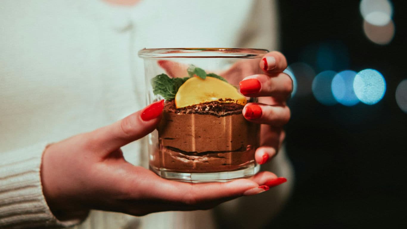 Woman holding dessert in glass jar